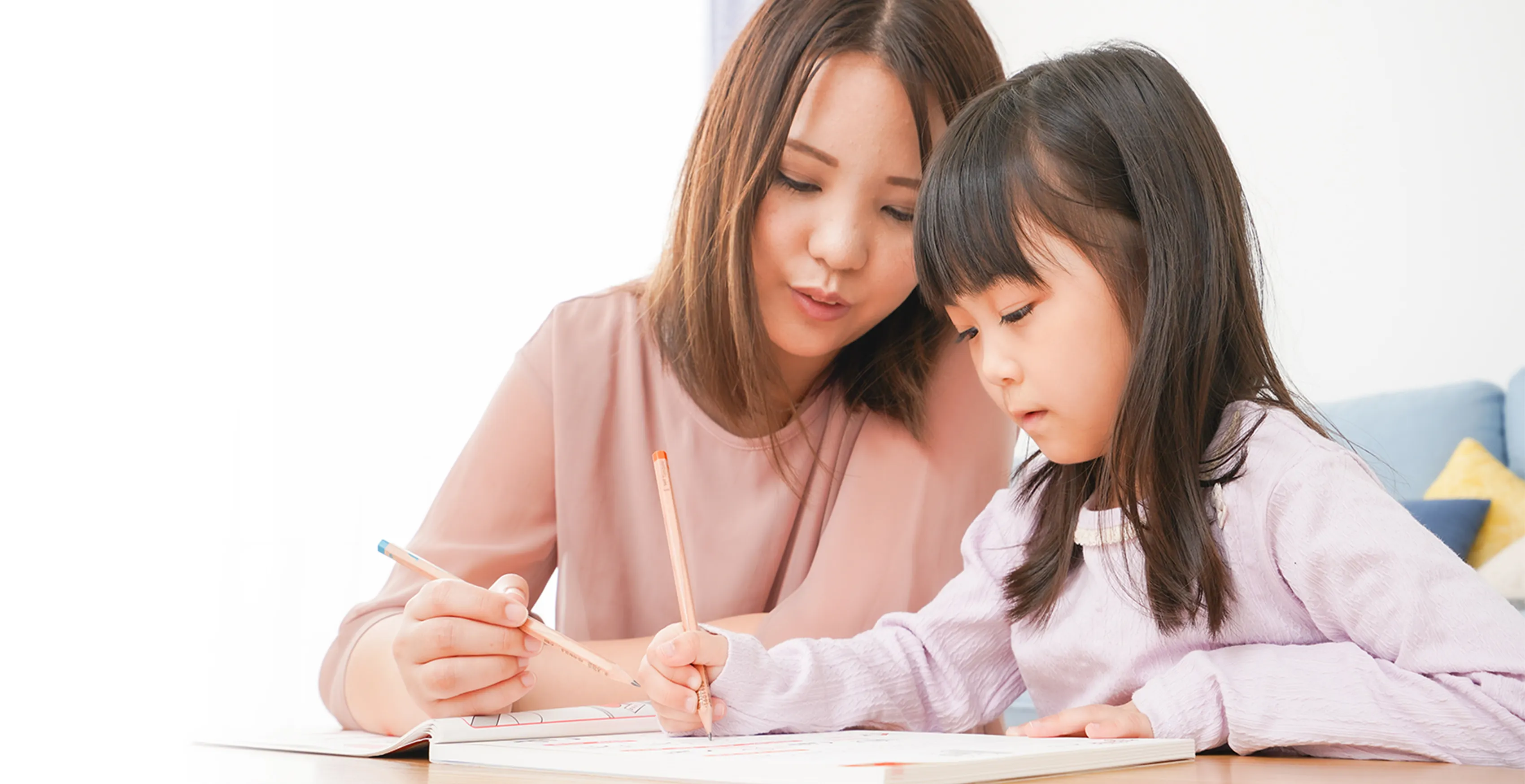 母親と一緒に宿題をしている女の子