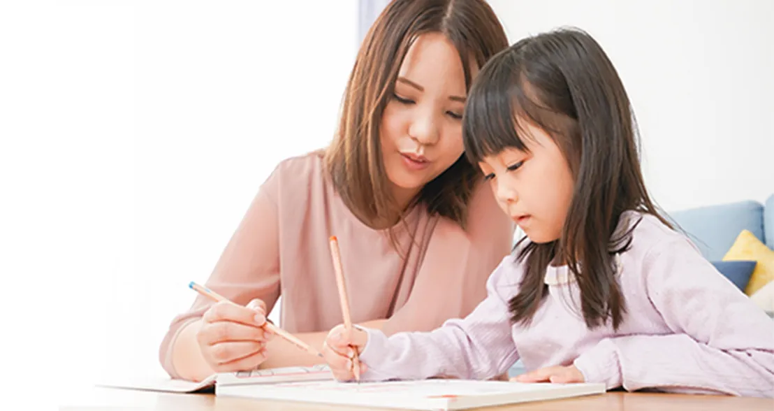 母親と一緒に宿題をしている女の子
